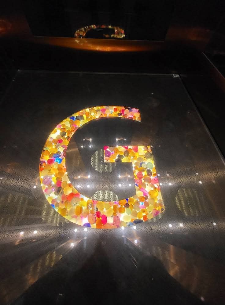 Lift cabin floor with a lit coloured-stone letter G inlay